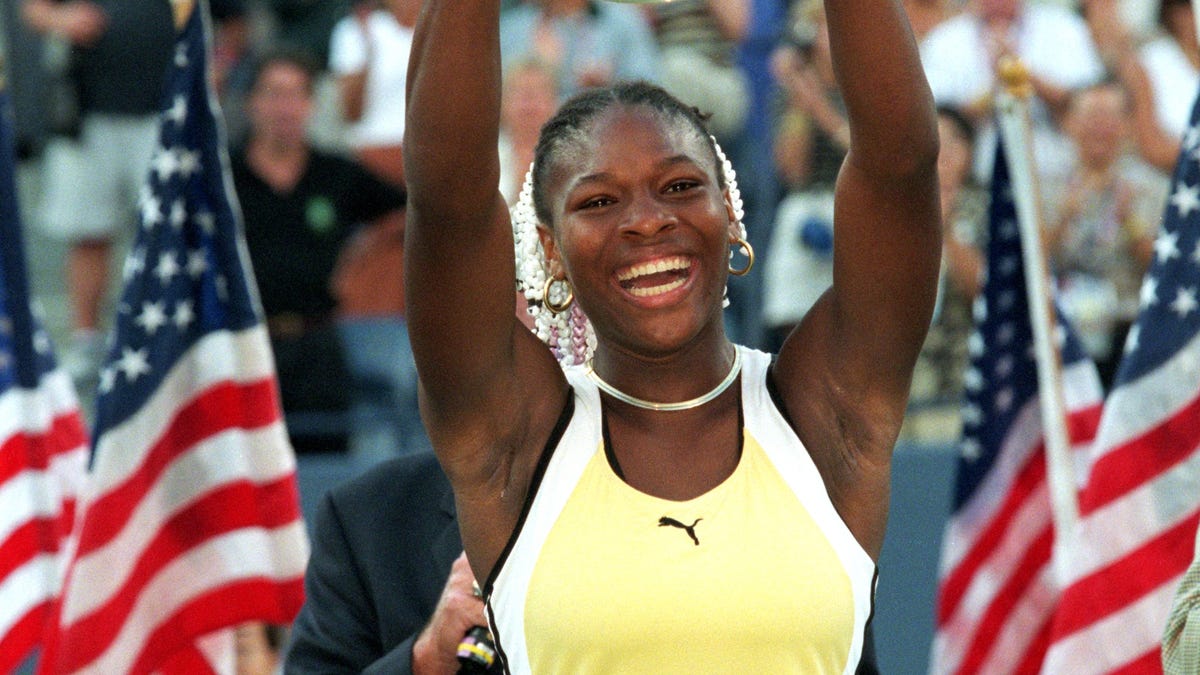 Serena Williams smiles and poses with her trophy after winning the US Open at the USTA National Tennis Courts in Flushing Meadows, New York, September 11, 1999.