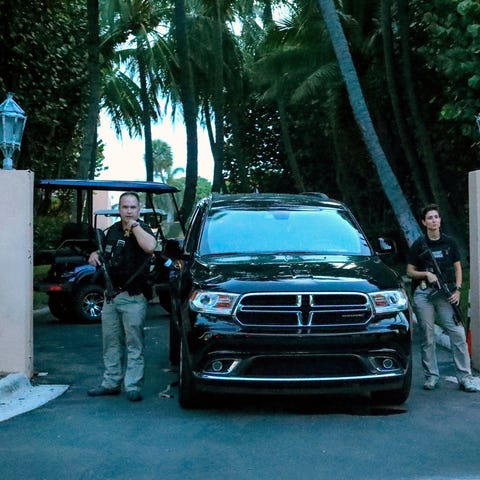 Secret service agents stand at the gate of Mar-a-L