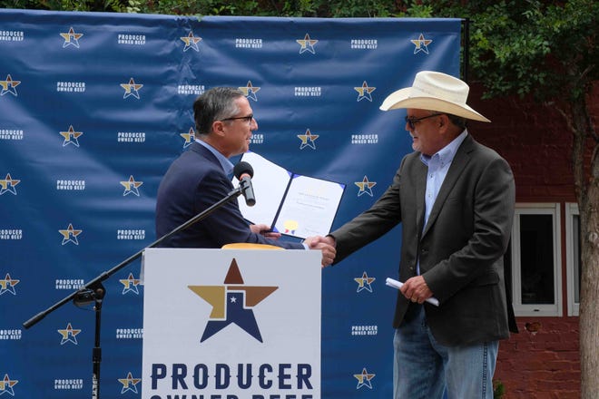 Monte Cluck, board member of Producer Owned Beef, receives a proclamation Wednesday from Texas Gov. Greg Abbott for the $12.2 million grant from the Texas Enterprise Fund.