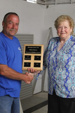 Cheboygan County Fair Board President Ron Fenlon (left) presented Dolores Peterson (right) with the first Cheboygan County Fair Dolores Peterson Exceptional Exhibitor Award, a prize named after Peterson for her 80 years of exhibiting at the county fair.