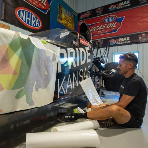 Travis Shumake pulls the vinyl decal to reveal the