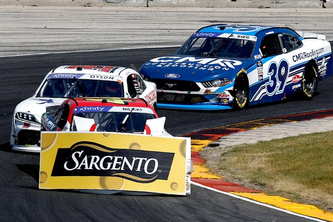 Un panneau publicitaire est accroché au nez de la voiture de Josh Bilicki après qu'il a été contraint de quitter la piste dans la série NASCAR Xfinity Henry 180 le 2 juillet à Road America.  L'incident a conduit à un parrainage d'une course de Sargento.