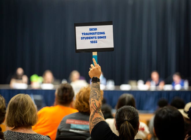 People attend a school board meeting on Tuesday, Aug. 9, 2022 at Miller Elementary School in Salem, Ore. The school board voted to ban concealed weapons on school property.