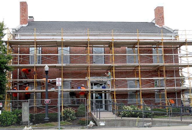 Employees of Umphress Masonry work on the front exterior of Bedford City Hall in August.