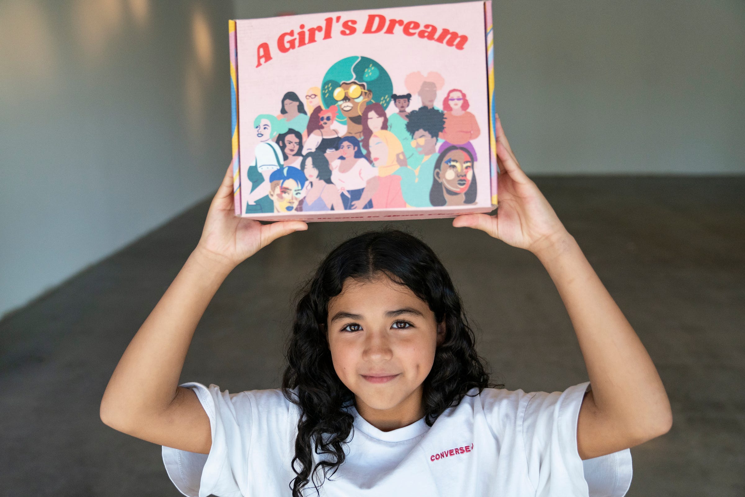 Lily Rodriguez, 11, hoists up a A Girl's Dream STEAM kit she received a few weeks prior at the Mexicantown Community Development Corporation in Detroit Wednesday, Aug. 10, 2022. A Girl's Dream have created an after school and weekend program with the goal of engaging young women of color in STEAM (Science, Technology, Engineering, Arts and Math) fields. The group has made kits that include a variety of project-oriented activities including paints and chia seeds etc.