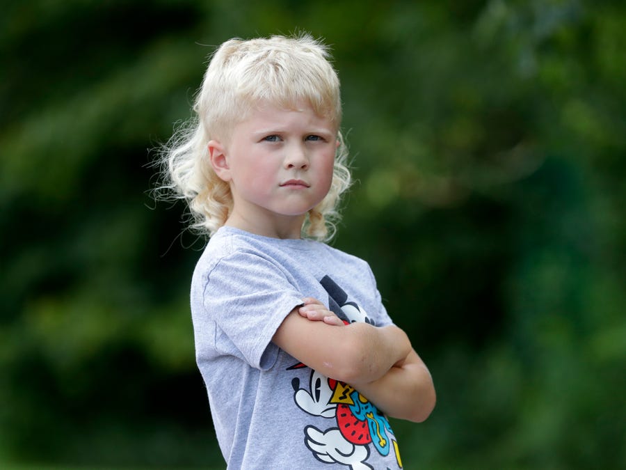 Axel Wenzel, 5, of Brillion is pictured on Aug. 3, 2022, outside Hemlock Creek Elementary School in the Town of Lawrence, Wis. Wenzel is a finalist in the 2022 USA Mullet Championships.