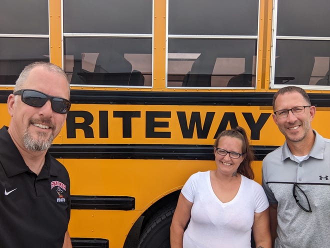 Pewaukee High School principal Brian Sniff (left) and Pewaukee High School athletic director Jeff Behrens (right) pose with their instructor Sarah (last name not provided) of Go Riteway. Both passed their driving tests to earn their commercial driver's licenses.