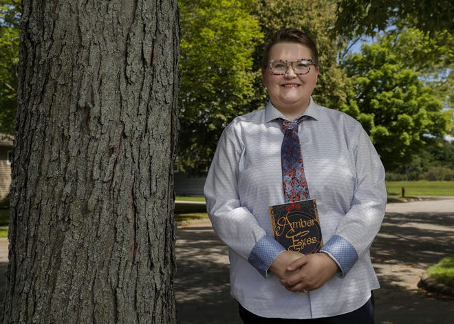 Eli Pritzl poses for a portrait on Aug. 11 outside their home in Wausau. Pritzl’s first book, “Amber Eyes,” is a fantasy novel that takes place in London in 1758 and follows Thaddeus Avalone, a teenage noble hiding his shapeshifting identity. The main character deals with parental abuse, anxiety and depression. Pritzl hopes the book will become a four- to five-book series. They’re currently writing the second novel.