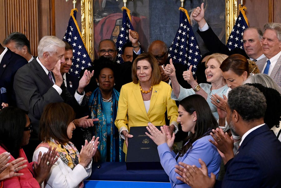 Lawmakers applaud US Speaker of the House Nancy Pelosi, D-Calif., after she signed the Inflation Reduction Act after the House of Representatives voted 220-207 to pass it at the US Capitol in Washington, DC, on August 12, 2022.