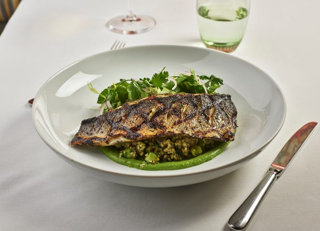 Spiced Mediterranean sea bass is a main-course selection offered on Cafe Boulud's three-course dinner menu.
