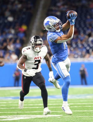 Lions wide receiver Amon-Ra St. Brown makes a catch against Falcons linebacker Mykal Walker (3) during the first half of the preseason game Aug. 12, 2022 at Ford Field.