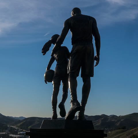 A bronze sculpture featuring Kobe Bryant and his d