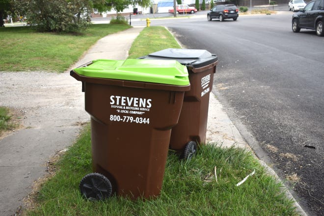 Two refuse totes provided by Stevens Disposal and Recycling Services, one for recycling and one for trash, are pictured Saturday, Aug. 13, 2022, out at the curb of a residence on Division Street in Adrian.