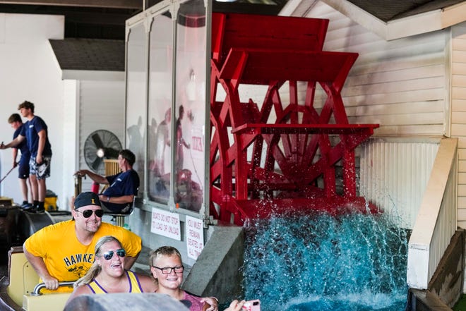 People hop onto the boats before riding Ye Old Mill during the Iowa State Fair Saturday, Aug. 13, 2022, in Des Moines.