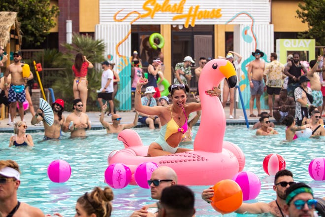 Ayesa Kearns smiles for the camera on an inflatable flamingo in the pool during weekend two of Splash House at Renaissance Hotel in Palm Springs, Calif., Saturday, Aug. 13, 2022. 