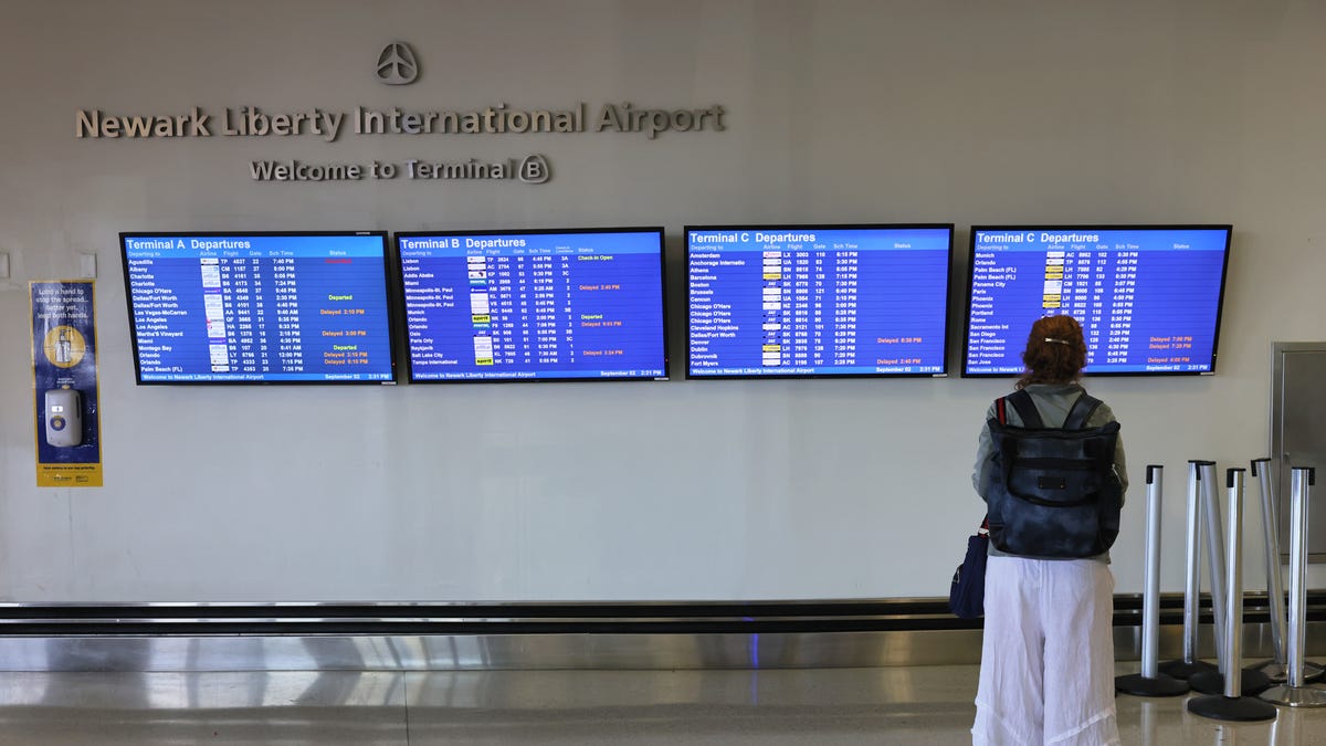NEWARK, NEW JERSEY - SEPTEMBER 02: A woman looks at a departure schedule in Terminal B at Newark Liberty Airport on September 02, 2021. (Photo by Michael M. Santiago/Getty Images)