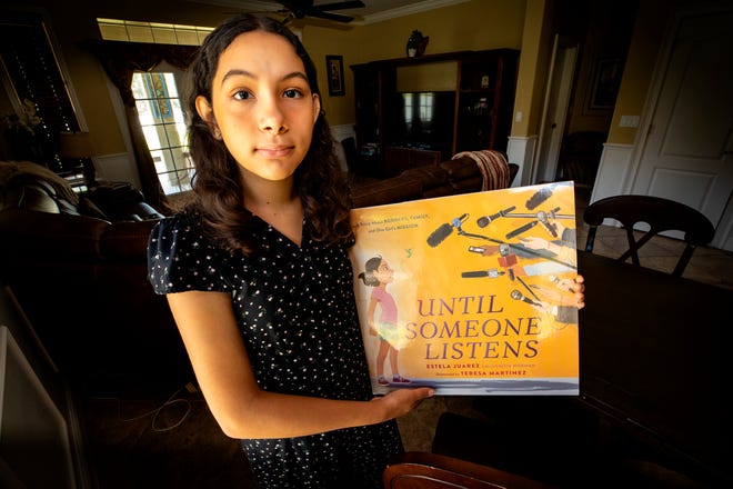 Estela Juarez, 13 , holds a promotional copy of the cover illustration of "Until Someone Listens," the picture book she co-authored. The book, due for publication Sept. 13, offers Estela's perspective on the experiences of her mother, Alejandra Juarez, an undocumented immigrant who was deported in 2018.