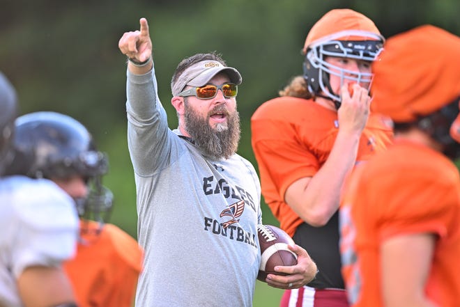 Osceola Grace Eagles head coach Ty Biller leads his team in a punting drill Monday, Aug. 15, 2022, at Osceola Grace Church in Osceola.