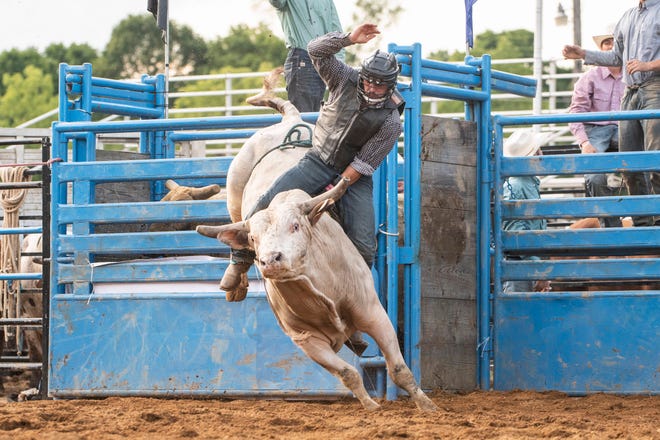 A bull rider performs during the Lost Nations Rodeo at the Calhoun County Fairgrounds in Marshall, Mich. on Monday, Aug. 15, 2022. The rodeo kicked off a week of grandstand events at the 173rd Calhoun County Fair.
