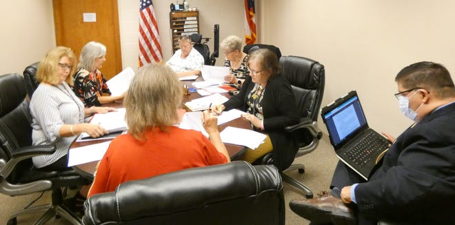 Members of the Crawford County Board of Elections and County Prosecutor Matt Crall, right, discuss potential ballot language for a November referendum vote on wind power during a meeting Tuesday in the board's office.