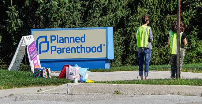 Anti-abortion rights protesters hand out anti-abortion literature, outside the entrance to Planned Parenthood - Georgetown Health Center on Tuesday, Aug.16, 2022, in Indianapolis. 