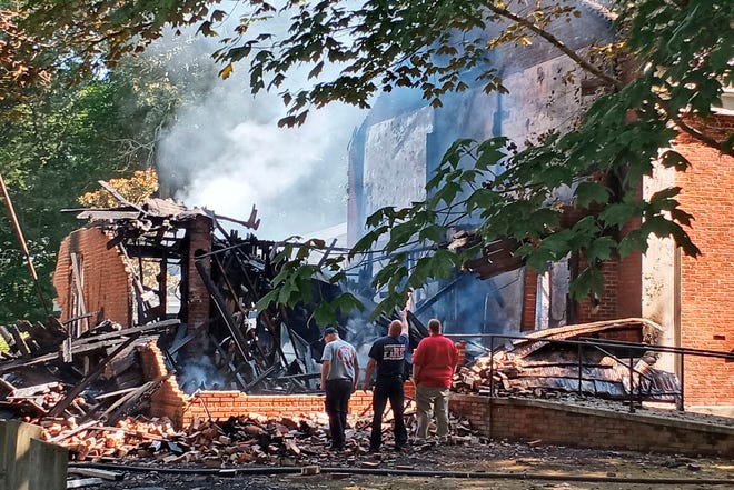 Lafayette County Fire Chief Wes Anderson, right, and county firefighters inspect the aftermath of a fire at College Hill Presbyterian Church near Oxford, Miss., Sunday morning, Aug. 14, 2022, after a Saturday night fire destroyed the majority of the historical structure. The church which was built in 1844, is where William Faulkner and his wife, Estelle, were married in 1929 — two decades before the novelist received the Nobel Prize in literature.