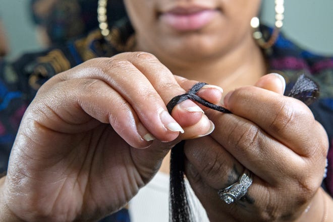 Tahli McLendon, 31, braids Sharell Franklin's hair at Thee Essenze Hair Salon and Barbershop near New Castle, Del.., on Tuesday, Aug. 16, 2022. McLendon braids hair for a living, an expression and profession rooted in personal, regional and cultural history, and she brings her art to Salisbury's National Folk Festival taking place from Aug. 26-28.