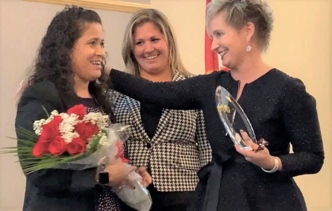Trish Giaccone, left, the CEO of the Family Life Center in Bunnell, is presented with the Volusia-Flagler area "Most Influential Woman in Business" award for 2021 from 2020 winner Julie Turpin, right, of Brown & Brown Insurance at an awards luncheon put on by The Daytona Beach News-Journal and Local iQ in October 2021. Also pictured, center, is Kaitlin Stier, regional event manager for The News-Journal and Local iQ.
