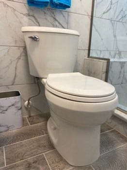 A new, low-flow toilet installed as part of a bathroom remodel.