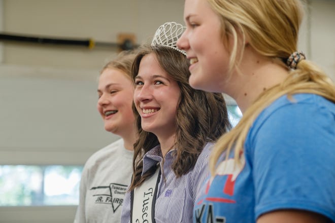2021 Tuscarawas County Fair Queen Riley Randolph flashes a smile while talking about her experiences traveling to fairs around Ohio, Tuesday, Aug. 16 at the Tuscarawas County Fairgrounds in Dover. Also pictured are 4-H members Ally Kendle, left, and Addy Kendle, far right.