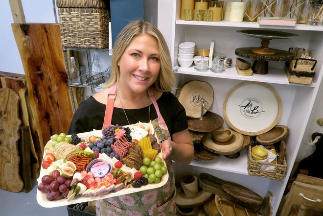Molly Boards owner Molly Kastner holds a ready-to-deliver charcuterie board inside her Point Pleasant Beach office Wednesday, August 17, 2022.
