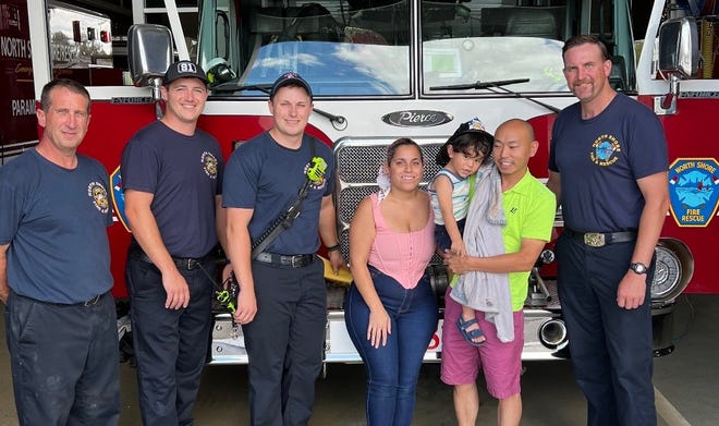 Two-year-old Isaac Velazquez and his family pose for a photo with North Shore Fire Rescue firefighters on July 30. Firefighter and paramedic Teagan Melin (three from left) helped rescue Isaac from drowning in Brown Deer on July 27.