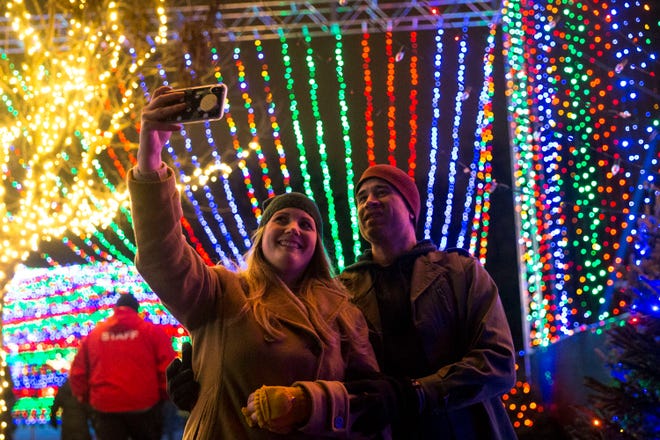 Allison Jenkins takes a selfie with her husband, Trey Jenkins, inside the Rainbow Tunnel at the fifth annual Trail of Lights preview party on Dec. 8, 2018, in Zilker Park.