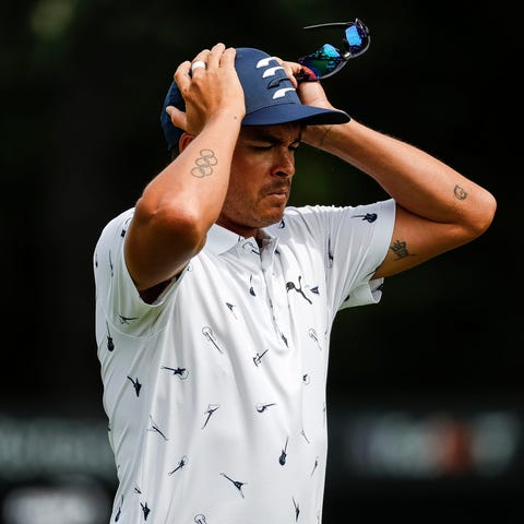 Rickie Fowler puts on his cap as he walks off the 