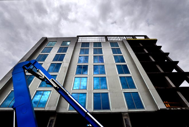 The sun and clouds are reflected in the windows of the DoubleTree by Hilton hotel under construction in downtown Abilene in mid-August.
