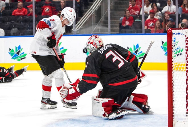 Canada goalie Dylan Garand (31) makes the save on Switzerland's Joel Henry (7) during the third period in a quarterfinal in the IIHF junior world hockey championships Wednesday in Edmonton.