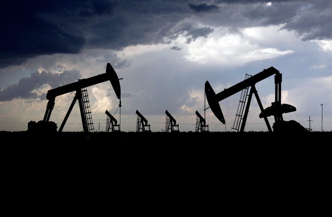 An array of pump jacks between Midland and Odessa, Texas, are shown in this file photo from May 14, 2020.