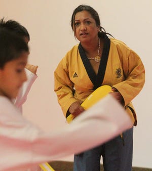 Kaushila Khanal Karmacharya, the owner of Sunshine Taekwondo Academy in Akron, leads a class.