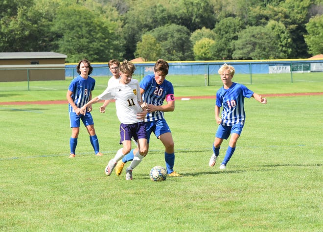 Lenawee Christian's Brady McKelvey (20) and Max Stamats look to create a takeaway while Blissfield's William Marks controls the ball during Thursday's match at LCS.