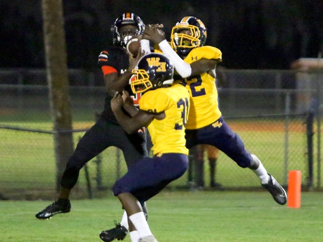 Lake Wales High wide receiver Diyante Landrum pulls down a touchdown pass as he is defended by Winter Haven High's Marlon Tullis and Dwayne Brown.