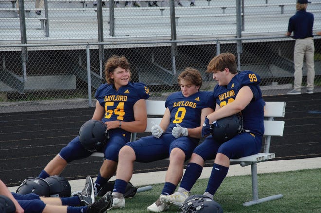 Three varsity players wait for their turn to take pictures at Gaylord football media day on Monday, August 15.