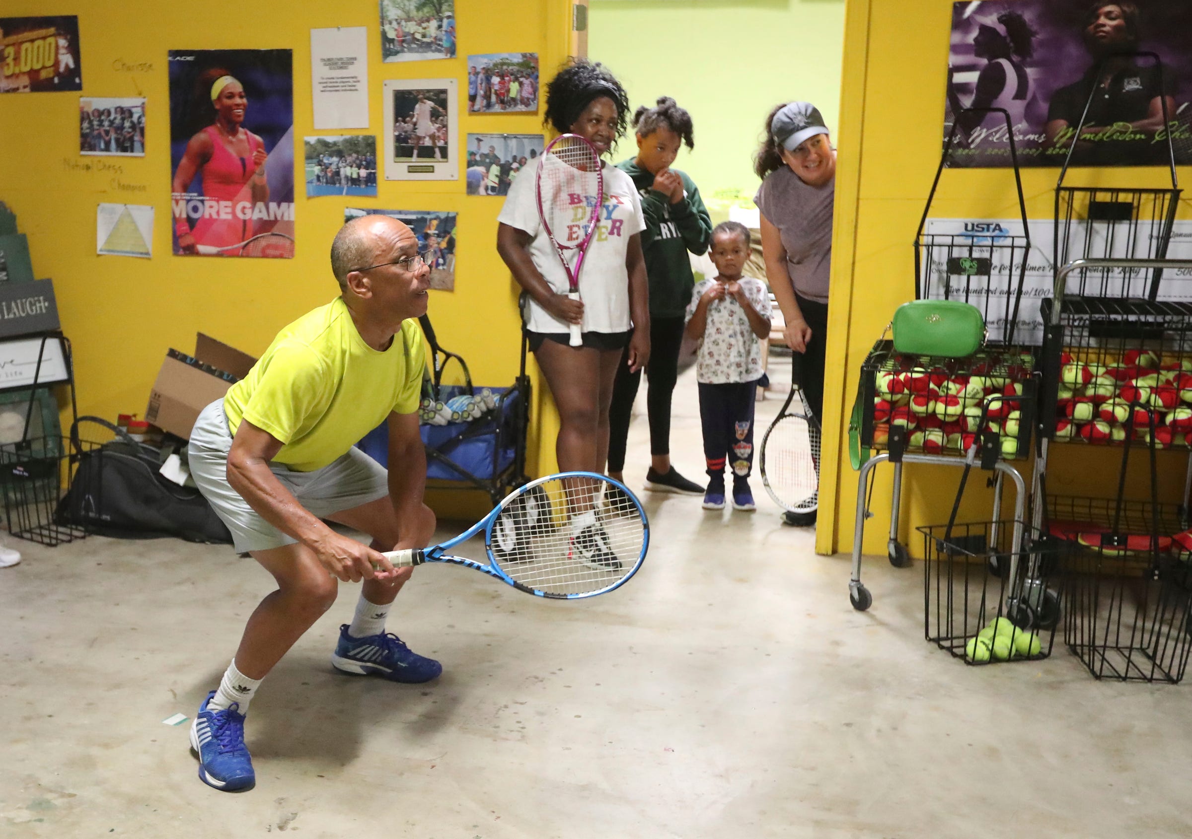 Jeff Collins works on returns as Chene Woodard, Kylee and Gregory Jackson and Maria Nederhood at a shed located near the Palmer Park courts in Detroit on August 18, 2022.  Collins is using teaching tennis as a way to celebrate his late wife of 36 years Lois Collins.