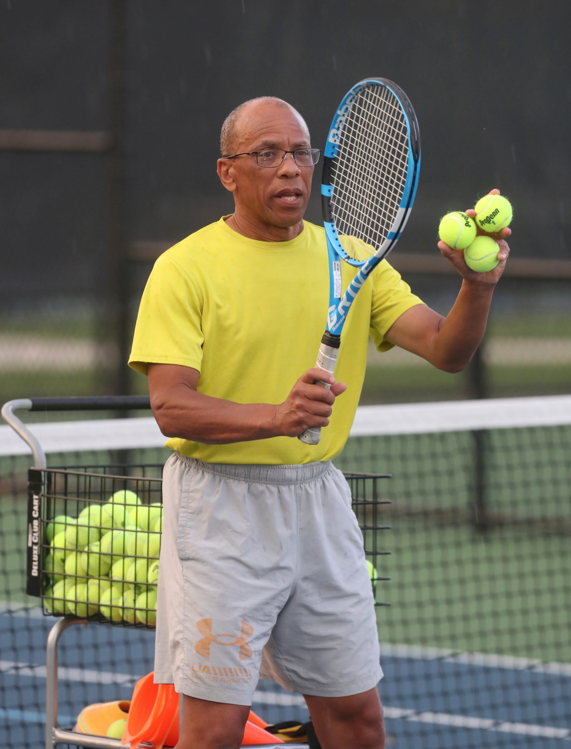 Jeff Collins gives tennis lessons to a small group of adults at the Palmer Park courts in Detroit on August 18, 2022.  Collins is using teaching tennis as a way to celebrate his late wife of 36 years Lois Collins.