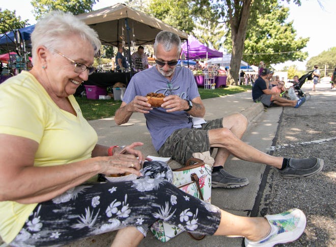 Sandy and Bill Dye of Lakeland eat pulled pork at the Food Truck Friday event in Pinckney Friday, Aug. 19, 2022.