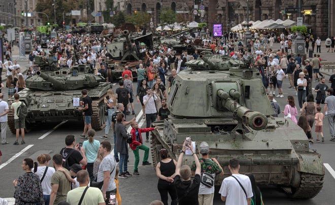 Ukrainians visit an avenue, where destroyed Russian military vehicles have been displayed in Kyiv, Ukraine, Saturday, Aug. 20, 2022. Drawing the attention of large numbers of pedestrians and amateur snappers on Saturday in downtown Kyiv a large column of burned out and captured Russian tanks and infantry carriers were displayed on the central Khreshchatyk boulevard. (AP Photo/Andrew Kravchenko) ORG XMIT: XSG119
