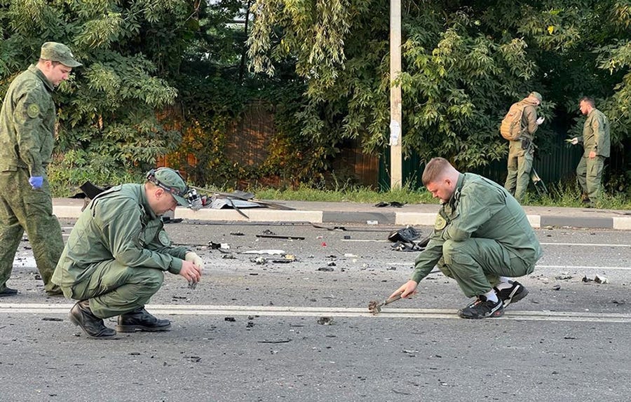 In this handout photo taken from video released by Investigative Committee of Russia on Sunday, Aug. 21, 2022, investigators work on the site of explosion of a car driven by Daria Dugina outside Moscow. Daria Dugina, the daughter of Alexander Dugin, the Russian nationalist ideologist often called "Putin's brain", was killed when her car exploded on the outskirts of Moscow, officials said Sunday. The Investigate Committee branch for the Moscow region said the Saturday night blast was caused by   a bomb planted in the SUV driven by Daria Dugina.(Investigative Committee of Russia via AP)