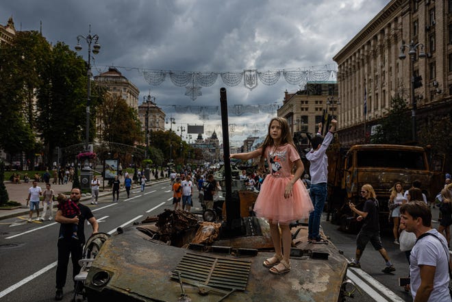 A girl stands on top of destroyed Russian military equipment at Khreshchatyk street in Kyiv on Aug. 20, 2022, that has been turned into an open-air military museum ahead of Ukraine's Independence Day on Aug. 24, amid Russia's invasion of Ukraine.