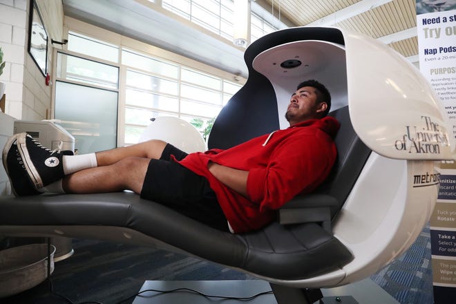 Aaron Martin, 18, an Ellet high school graduate and freshman at the University of Akron, enjoys one of the two MetroNaps EnergyPods in Simmons Hall on Monday. The university has four pods in three locations on campus for students to use.