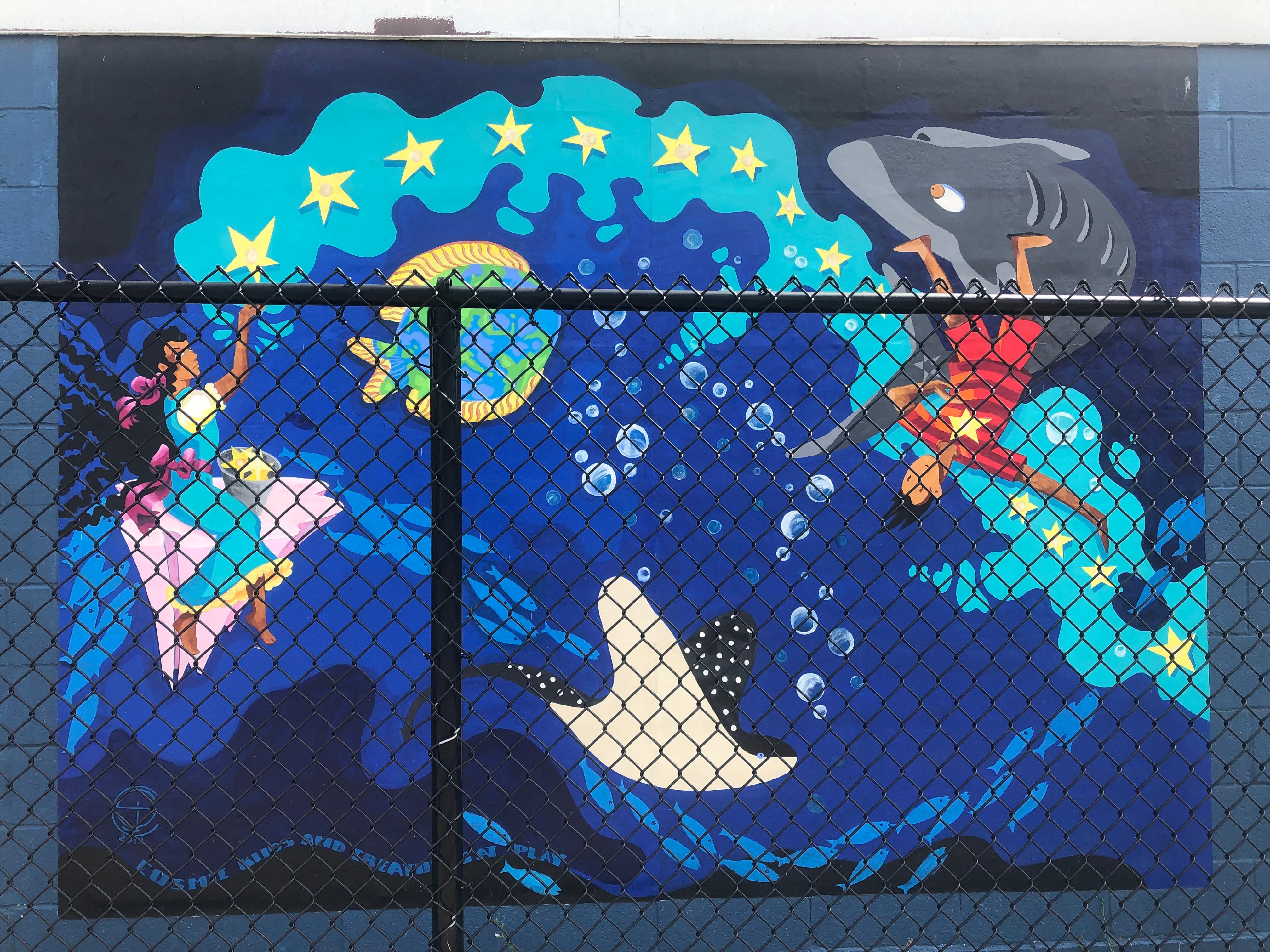 An underwater scene painted by Susan Champeny in 2019 in Floral Ave. Park at 200 Floral Ave. in Johnson City depicts a school of fish swimming across it.