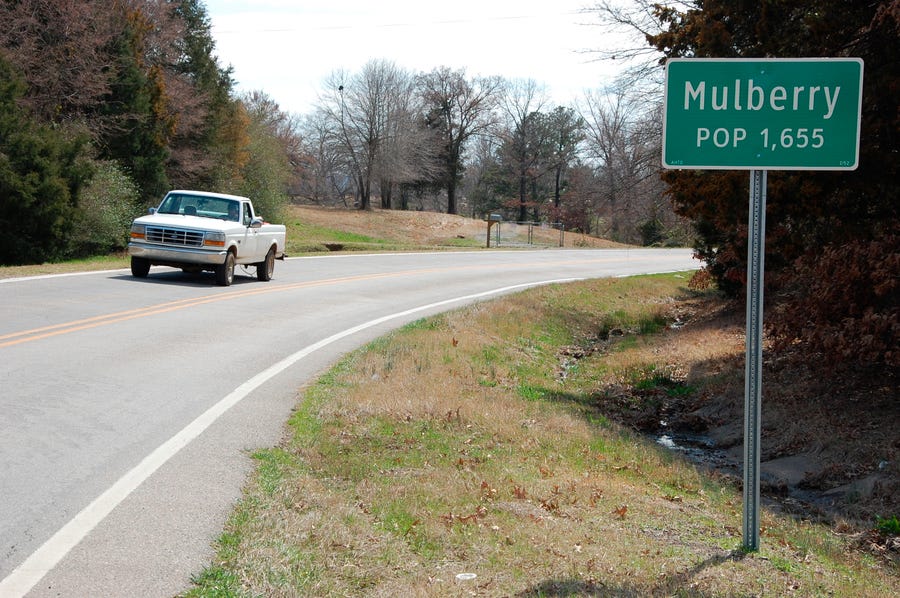A truck drives near a population sign in Mulberry, Ark., on March 13, 2013. Three law enforcement officers in Arkansas have been suspended after a video posted on social media showed a suspect being held down on the ground and beaten by police. Arkansas State Police said Sunday, Aug. 21, 2022 that it would investigate the use of force by the officers earlier in the day outside a convenience store in Mulberry.
